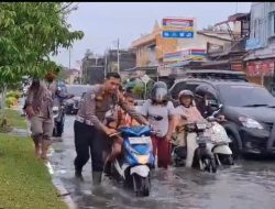 Aksi heroik Satlantas Dumai di tengah banjir, rela basah basahan gendong anak sekolah dan dorong motor mogok